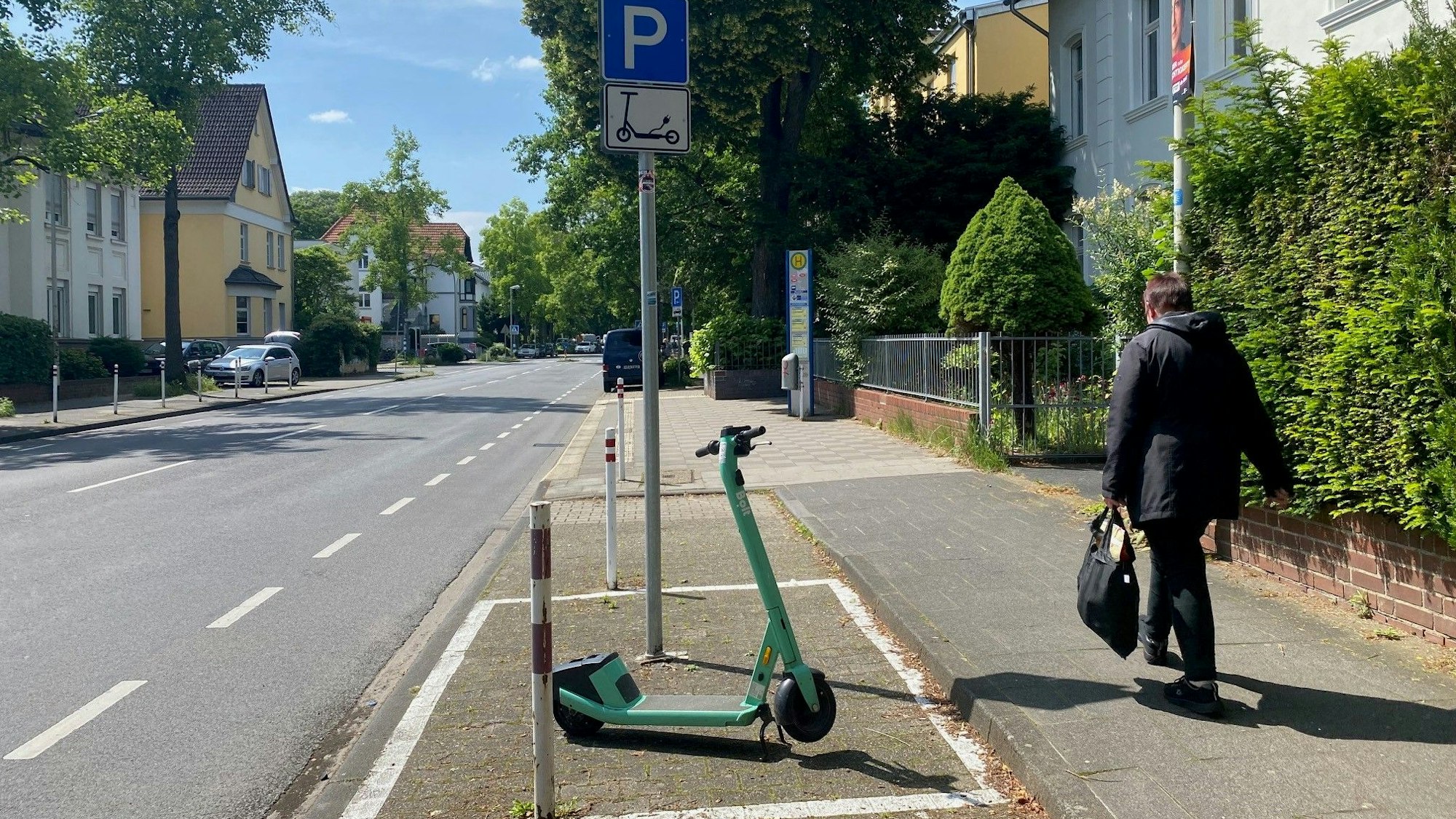 Zu sehen ist eine mit Schild und Markierung gekennzeichnete Abstellzone an einer Straße.