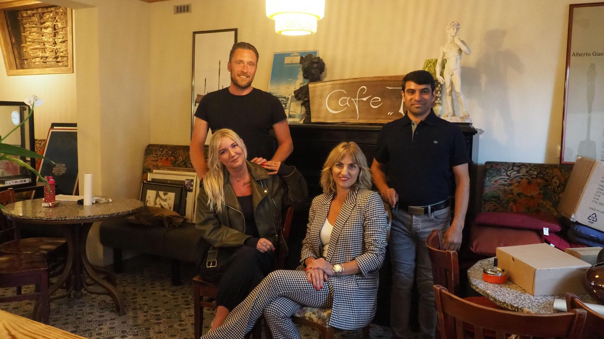 Markus Prusko und Sadeq Ali Hosseine stehen hinter Angela Dar und Jeanette Heinzen, die es sich auf Stühlen bequem gemacht haben.