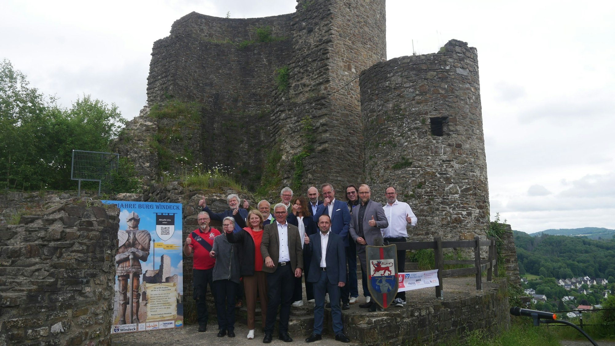 Menschen stehen vor einer Burgruine.