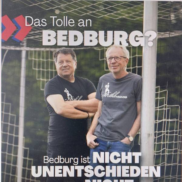 Zwei Männer stehen an einem Torpfosten.