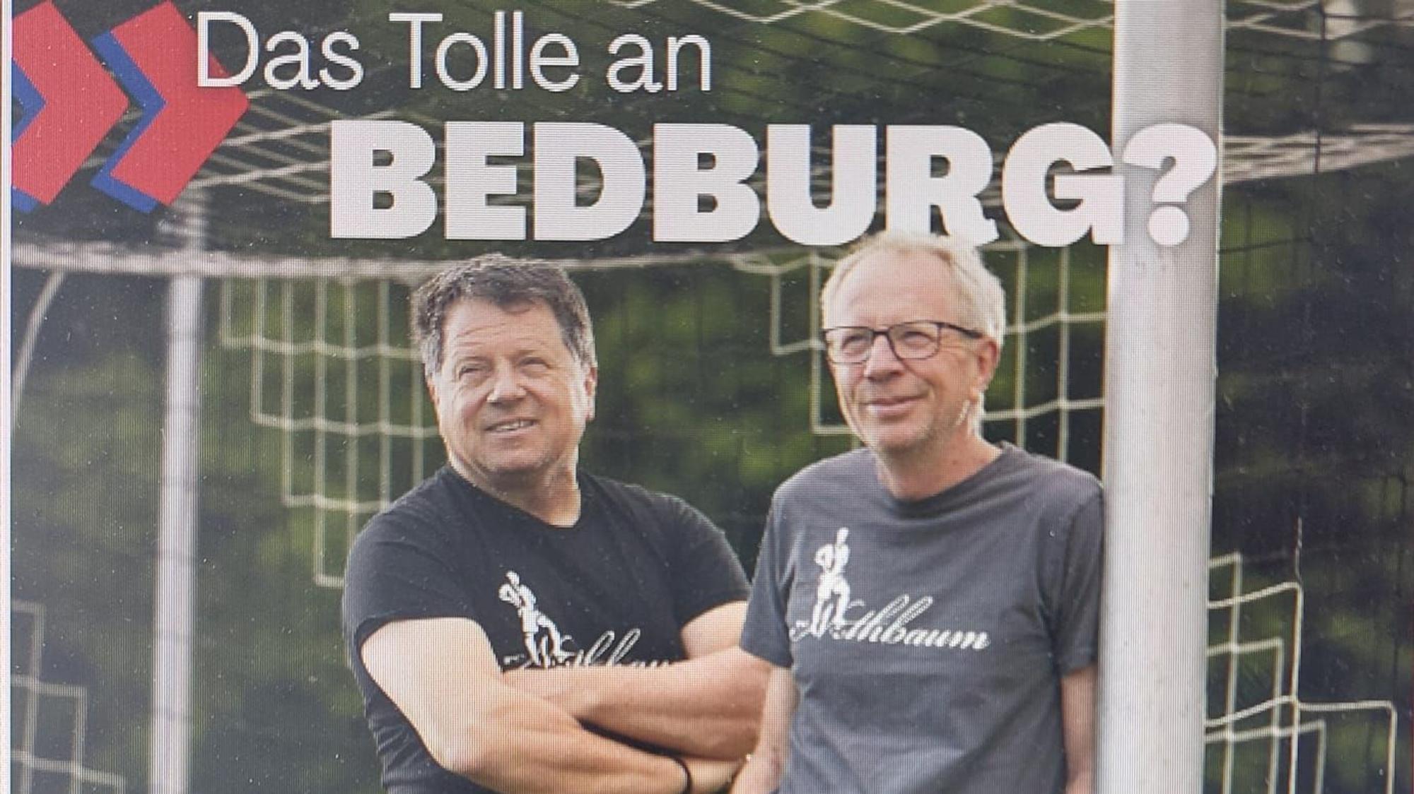 Zwei Männer stehen an einem Torpfosten.