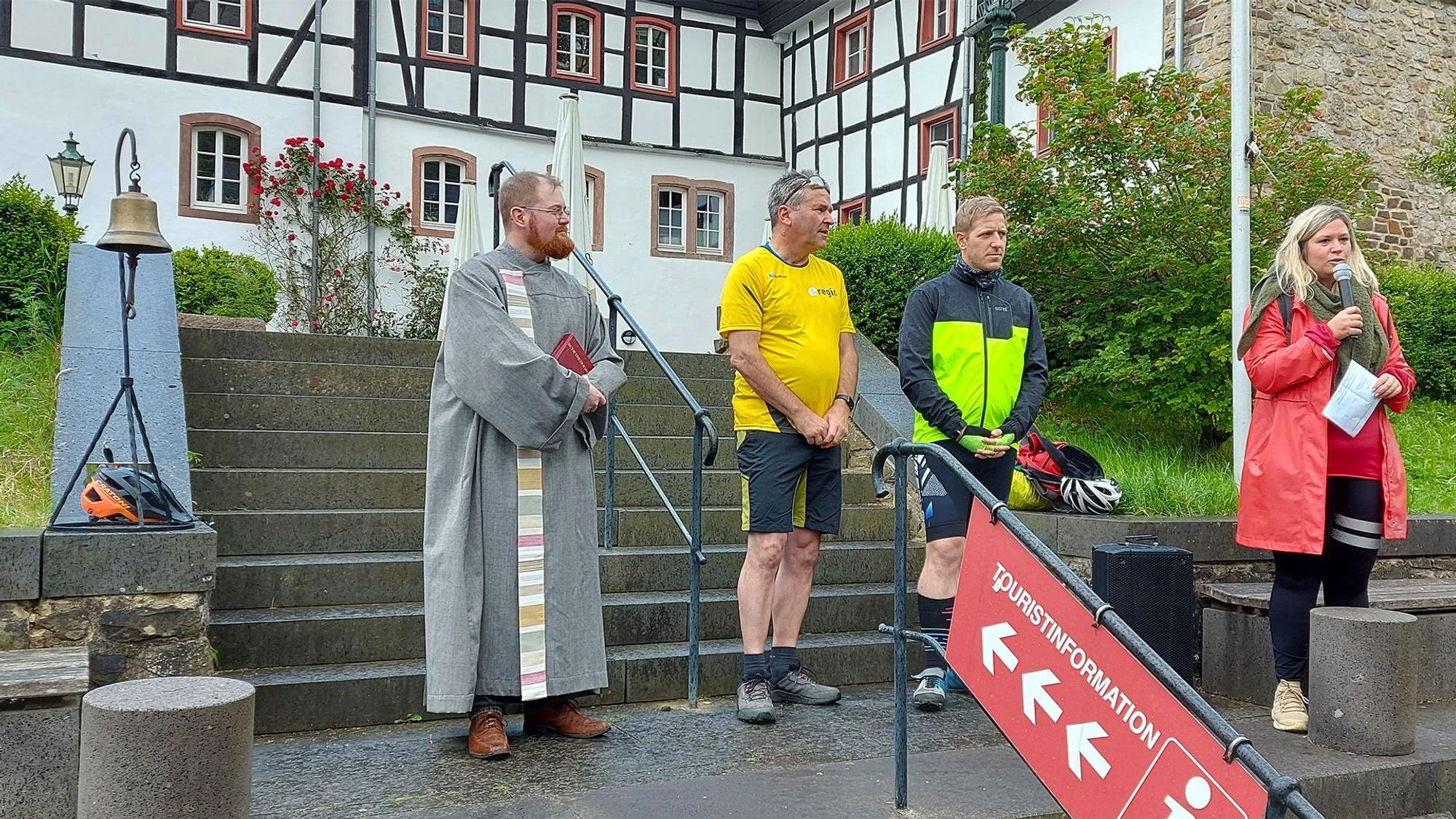 Die vier Genannten auf den Stufen vor der Blankenheimer Touristen-Information. Bürgermeisterin Jennifer Meuren spricht zu den Radlern.