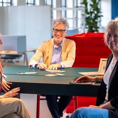 Isabelle Jaeschke, Iris Poth und Sarah Komp sitzen an einem Tisch.