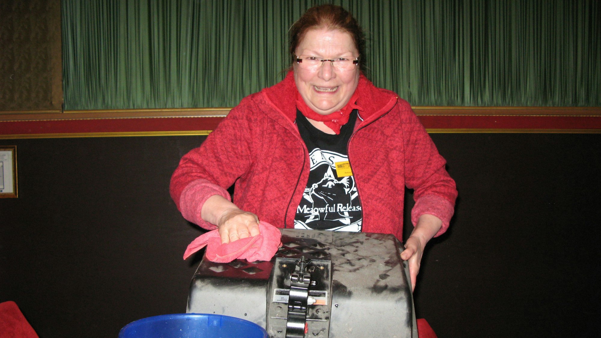 Eine Frau wischt mit einem Putzlappen einen staubigen Lautsprecher ab.