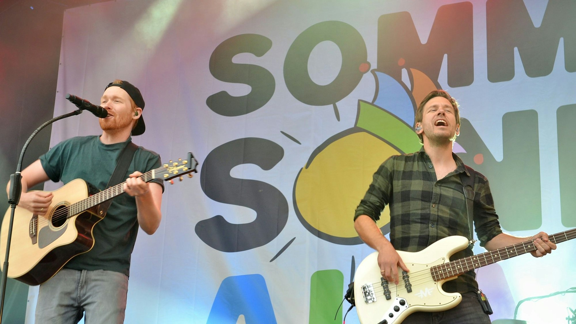 Zwei Musiker der Band der Gruppe „Miljö“ stehen auf der Bühne.