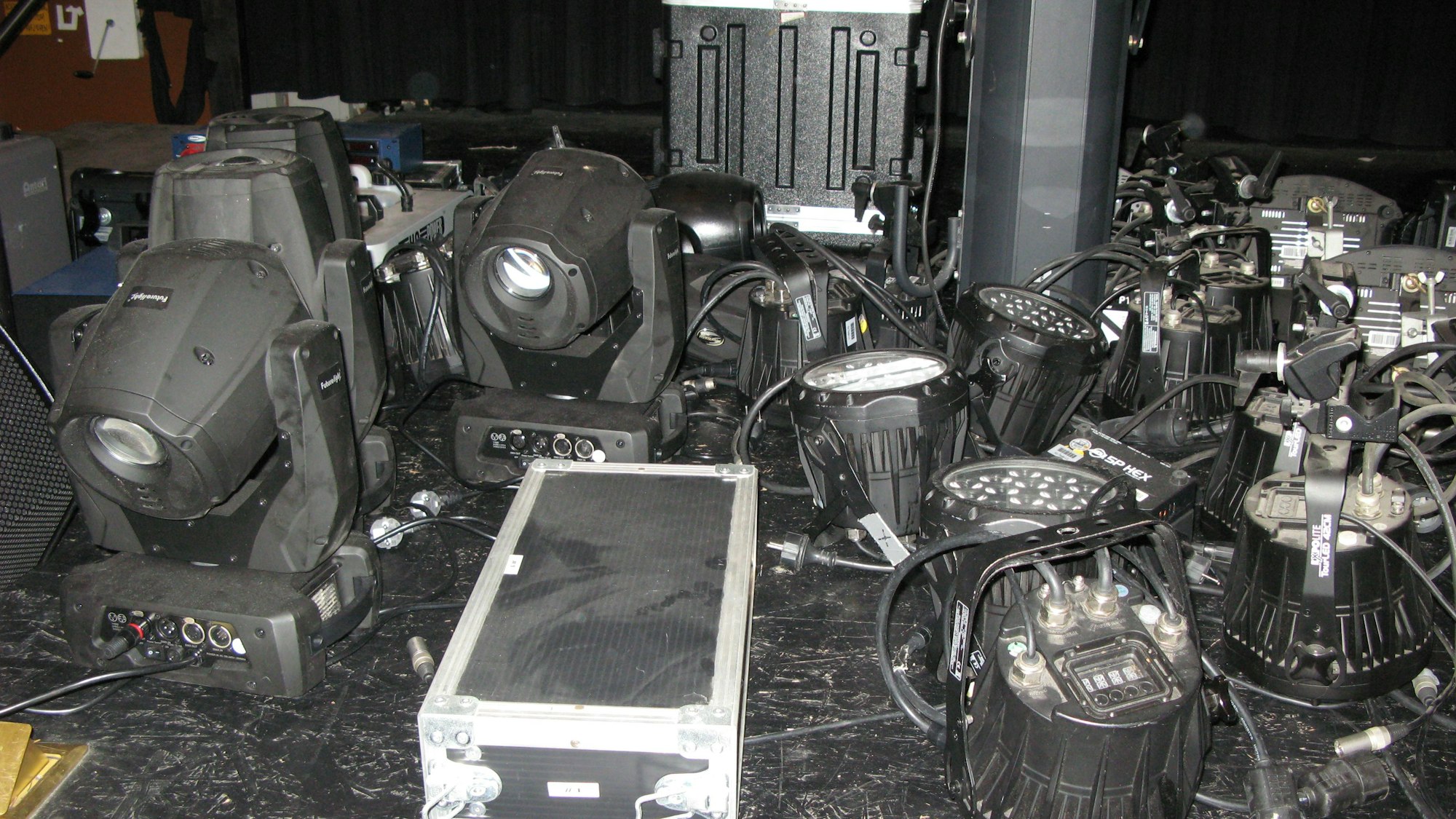 Auf der Bühne des Kur-Theaters stehen zahlreiche abmontierte Scheinwerfer und Koffer mit technischem Equipment.