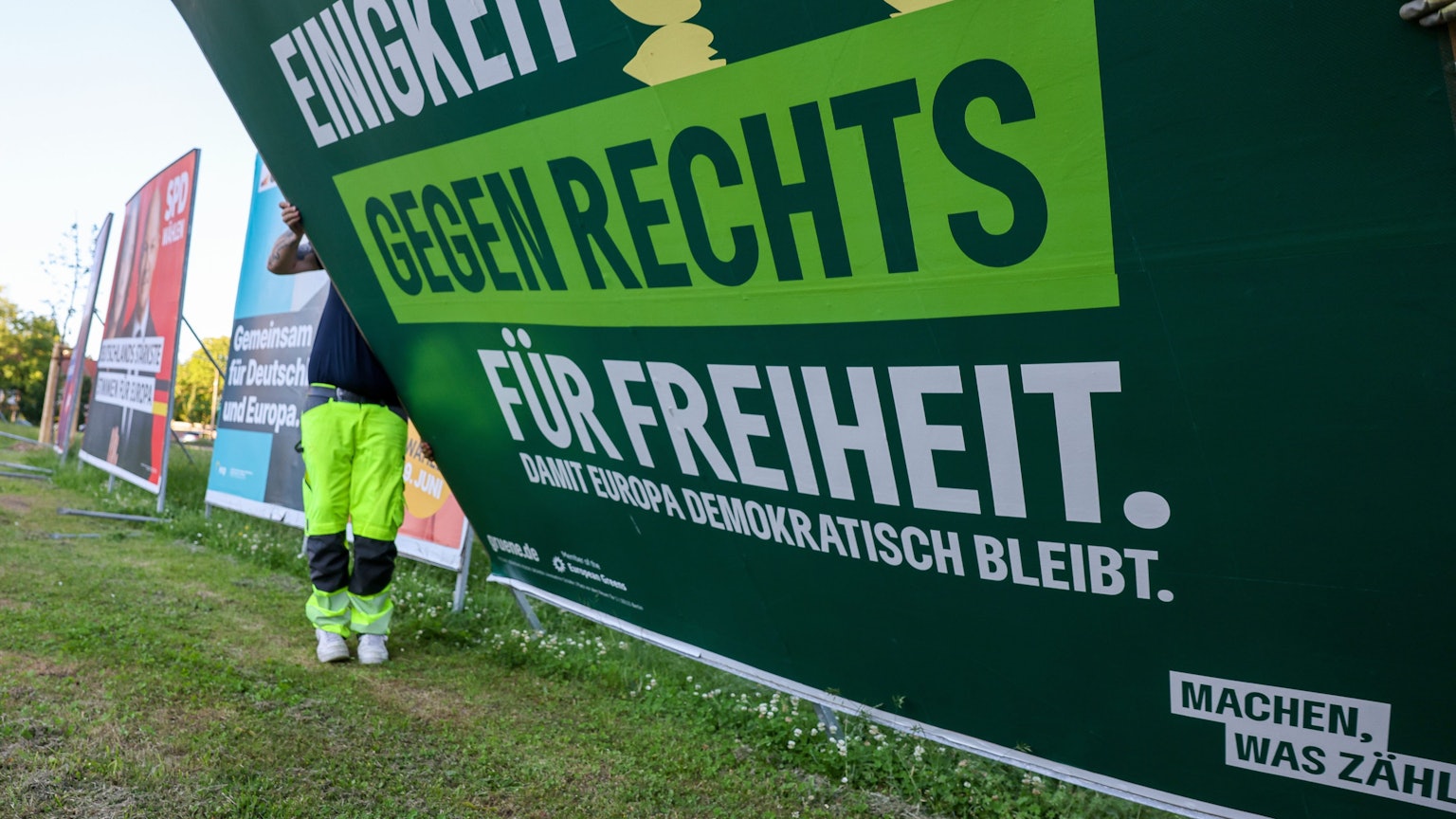 Zwei Mitarbeiter einer Firma für Werbeaufsteller bauen ein Wahlplakat der Partei ·Bündnis 90/Die Grünen· nach der Europawahl ab. Die Grünen haben viele Stimmen verloren.