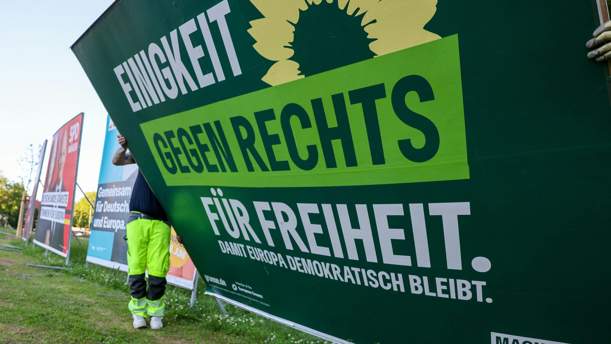 Zwei Mitarbeiter einer Firma für Werbeaufsteller bauen ein Wahlplakat der Partei ·Bündnis 90/Die Grünen· nach der Europawahl ab. Die Grünen haben viele Stimmen verloren.