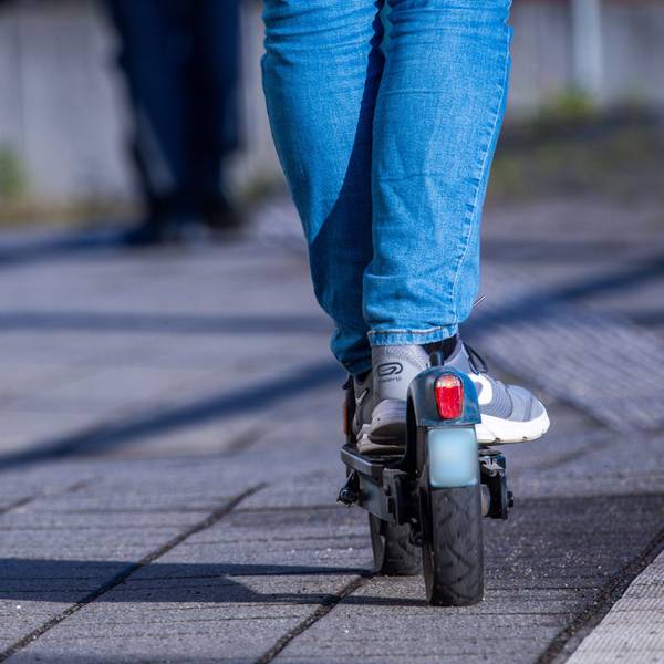 Das Bild zeigt einen E-Scooter-Fahrer von der Rückseite.