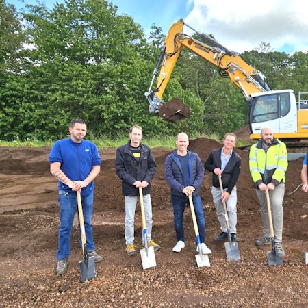 Marc Hees (v.l.), Stefan Jovy, Markus Auel, Mike Breitegger, Christoph Graf und Manfred Poth stehen mit Spaten vor einem Bagger.