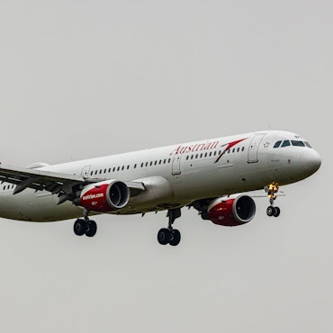 Ein rot-weiß-lackierter Airbus A320 der österreichischen Fluggesellschaft Austrian Airlines im Landeanflug auf einen Flughafen. (Symbolbild)