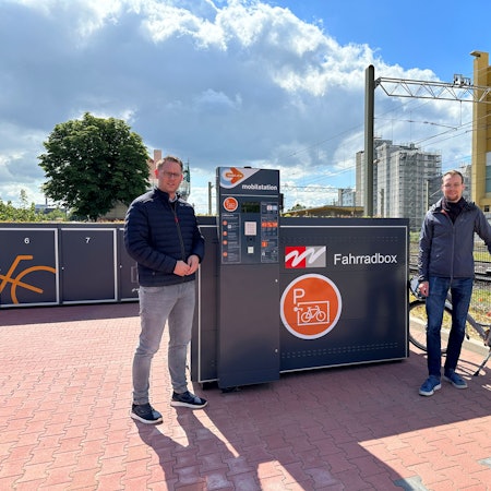 Auf dem Foto sind Mitarbeiter der Stadt Wesseling vor den neuen Fahrradboxen zu sehen.