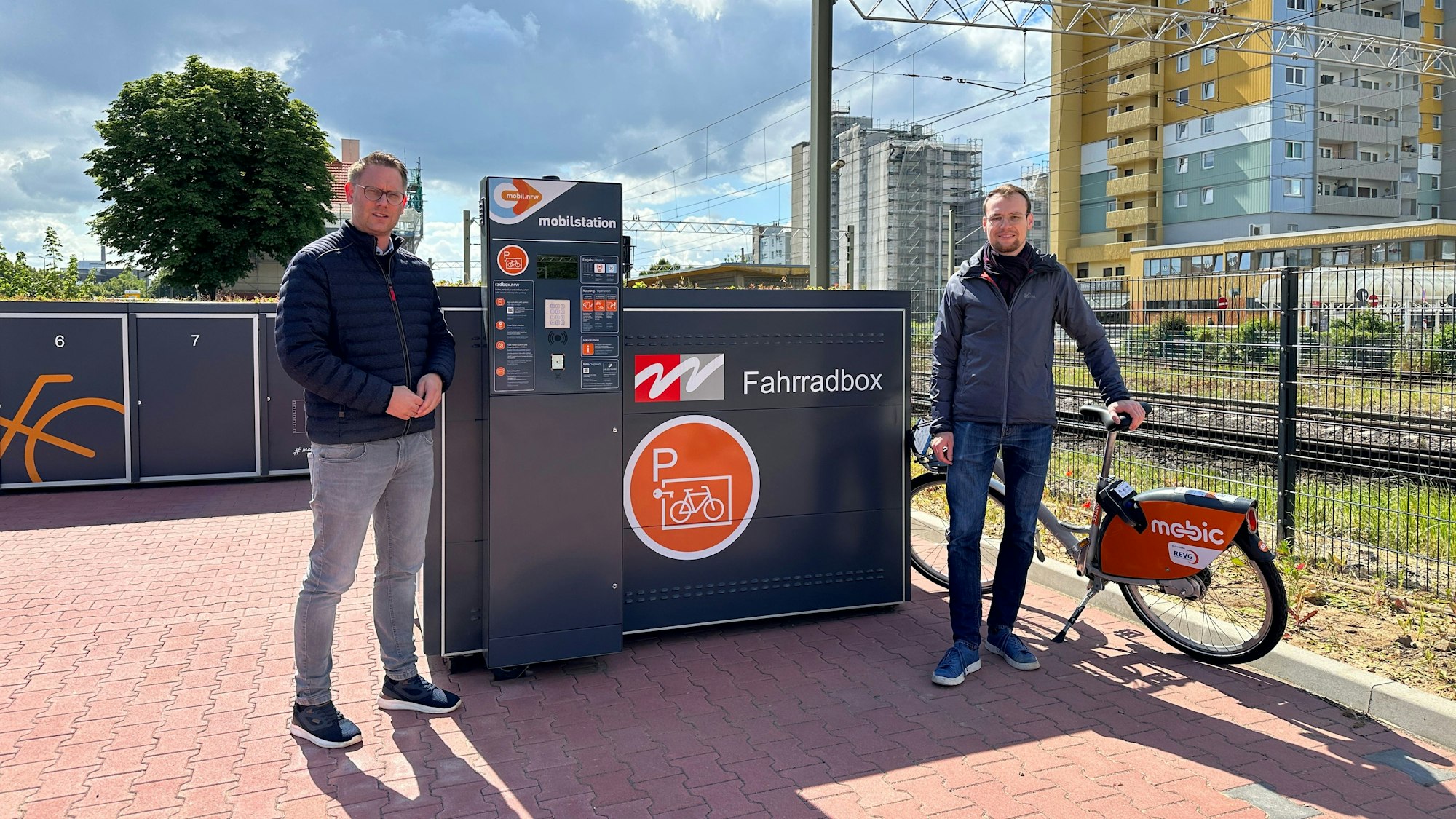 Auf dem Foto sind Mitarbeiter der Stadt Wesseling vor den neuen Fahrradboxen zu sehen.