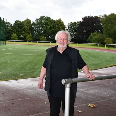 Das Foto zeigt den Klinikunternehmer und Vorsitzenden des FC Hürth, Alfons Domma, auf der Sportanlage hinter dem Gymnasium.