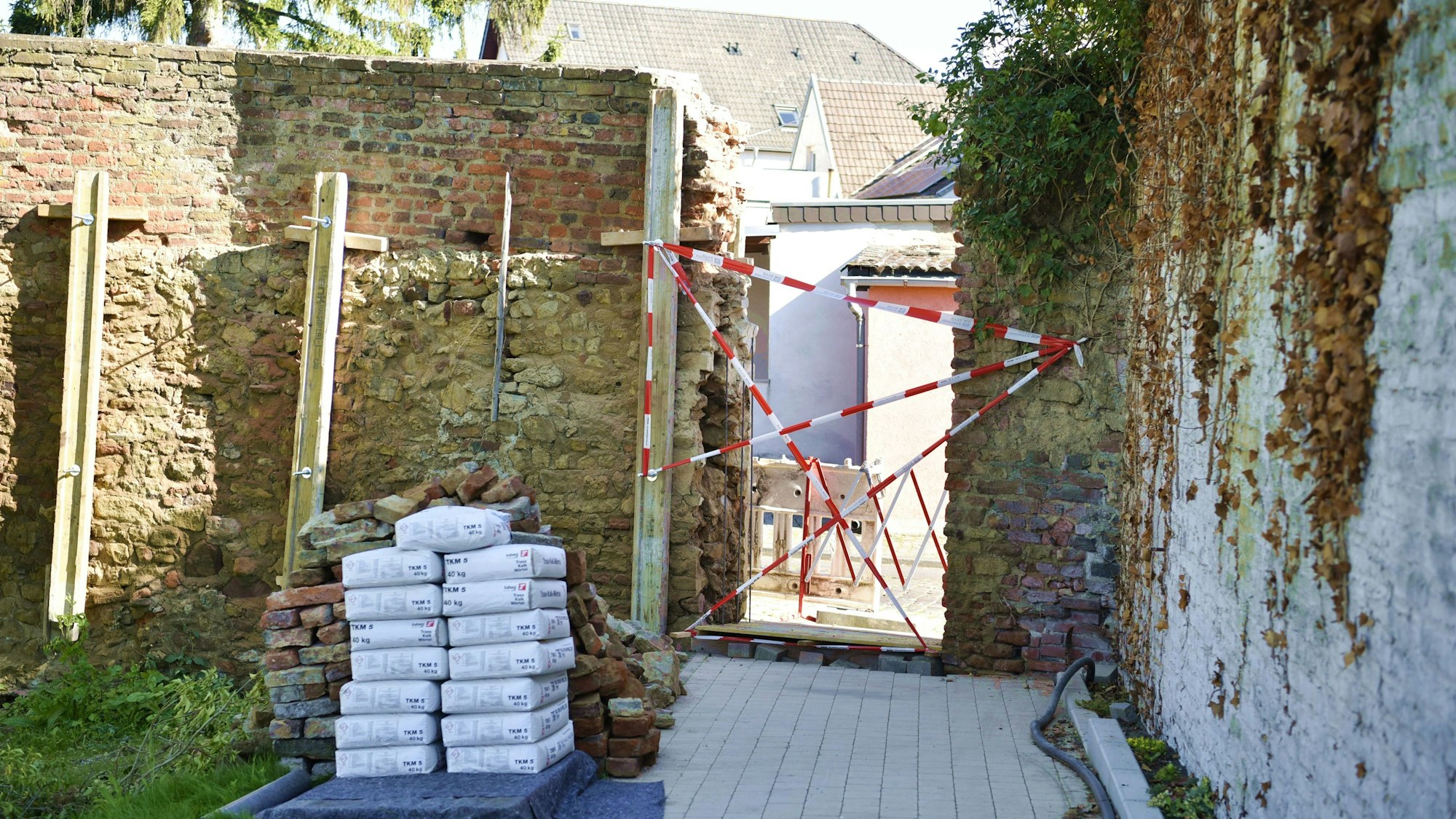 Die Stadtmauer in Zülpich wurde hinter dem Parkplatz an der Nideggener Straße durchbrochen, hier entsteht eine Schlupfpforte. Noch ist der Durchgang versperrt.