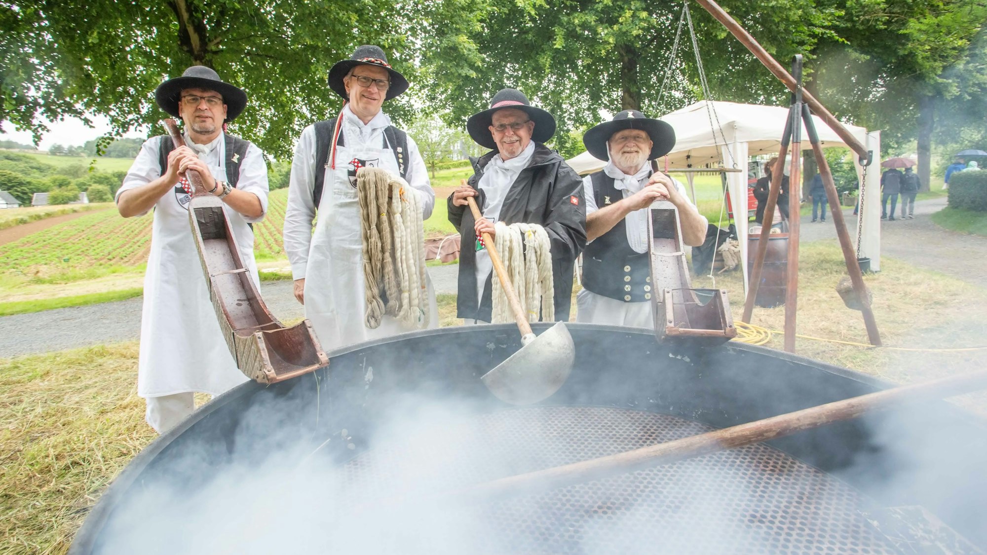 Torsten Reinoff, Andreas Volkmann, Matias Schmitz und Gerhard Constapel stehen in historischen Kostümen um einen dampfenden Trog.