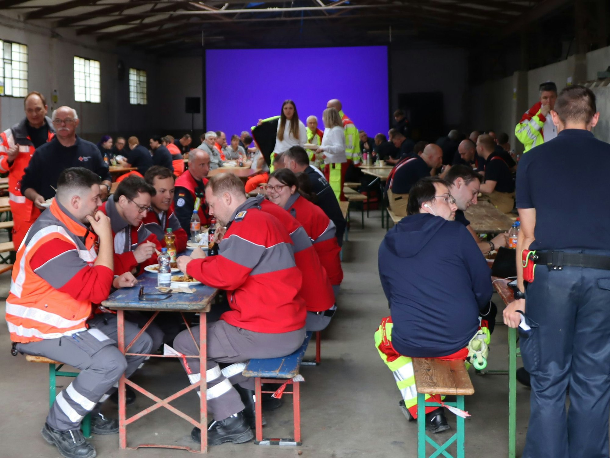 Das Bild zeigt mehrere Einsatzkräfte in einer Halle.