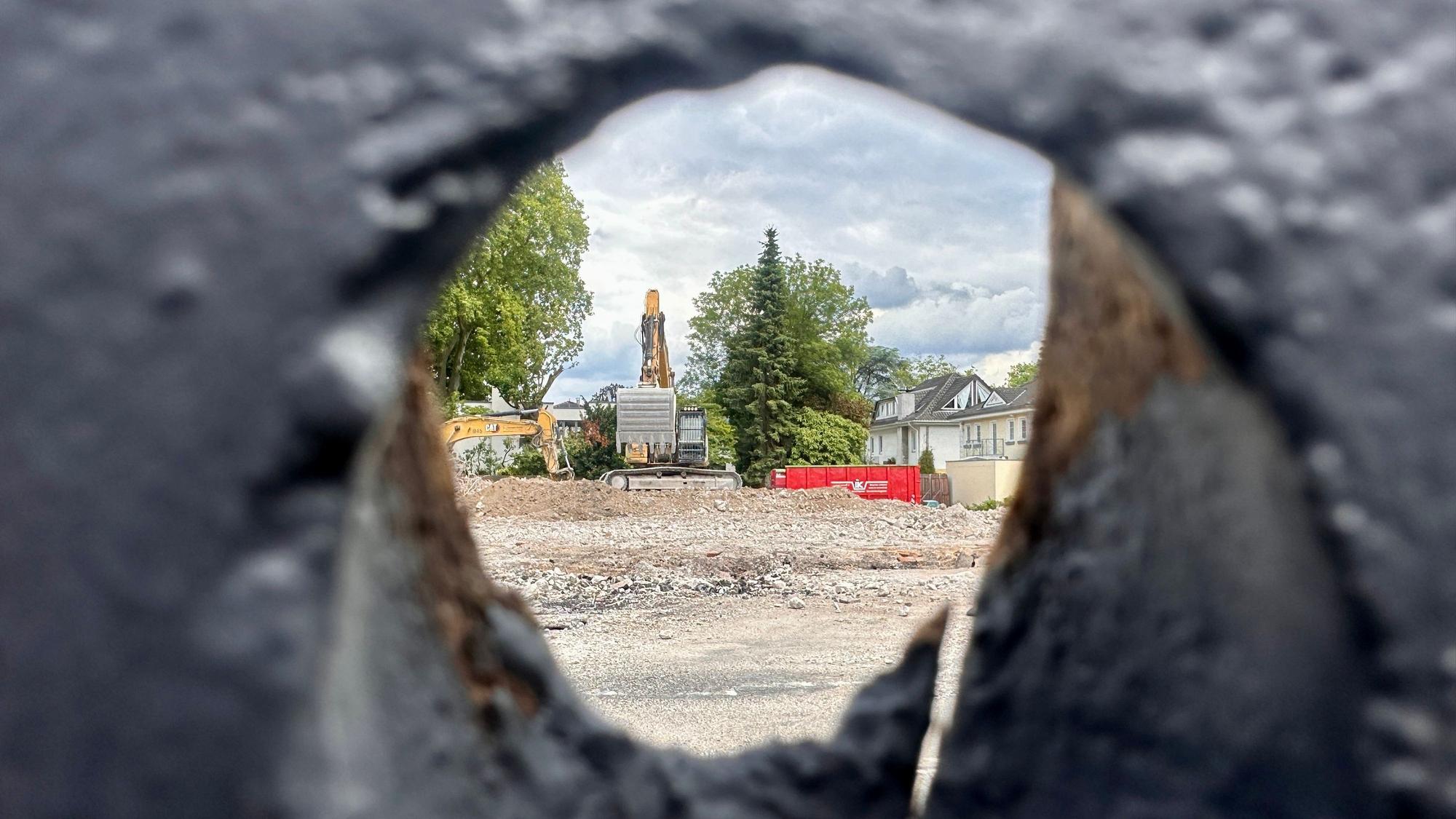 Ein Blick durch den Bauzaun, hinter dem das alte Rathaus in Rodenkirchen bereits abgerissen wurde.