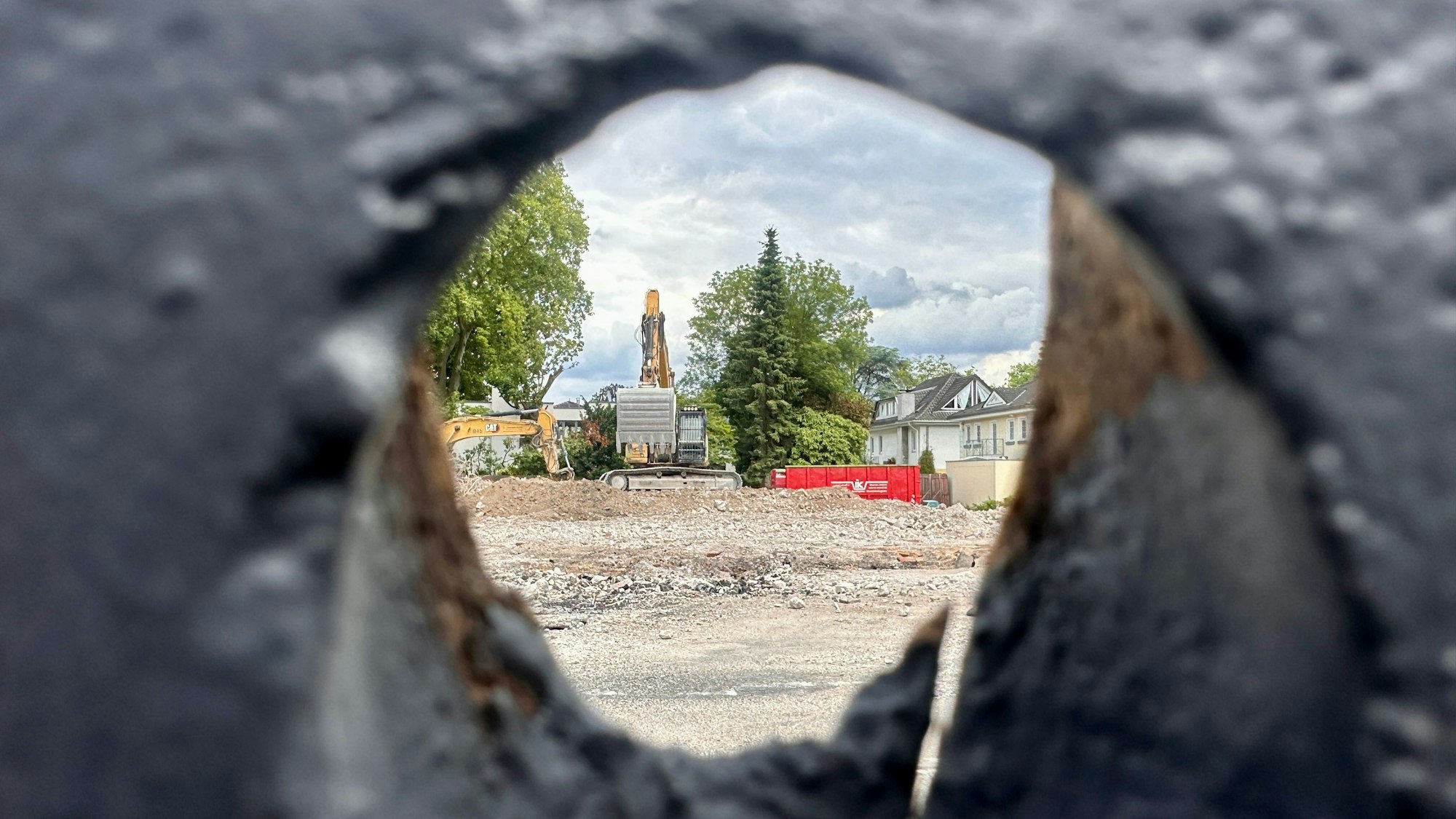 Ein Blick durch den Bauzaun, hinter dem das alte Rathaus in Rodenkirchen bereits abgerissen wurde.