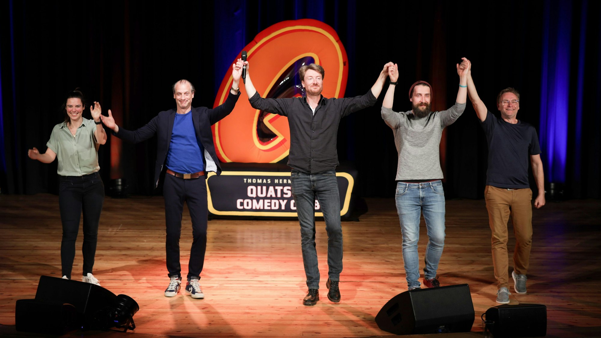 Die fünf Comedians haben sich an den Händen gefasst und bedanken sich beim Publikum für den Applaus.