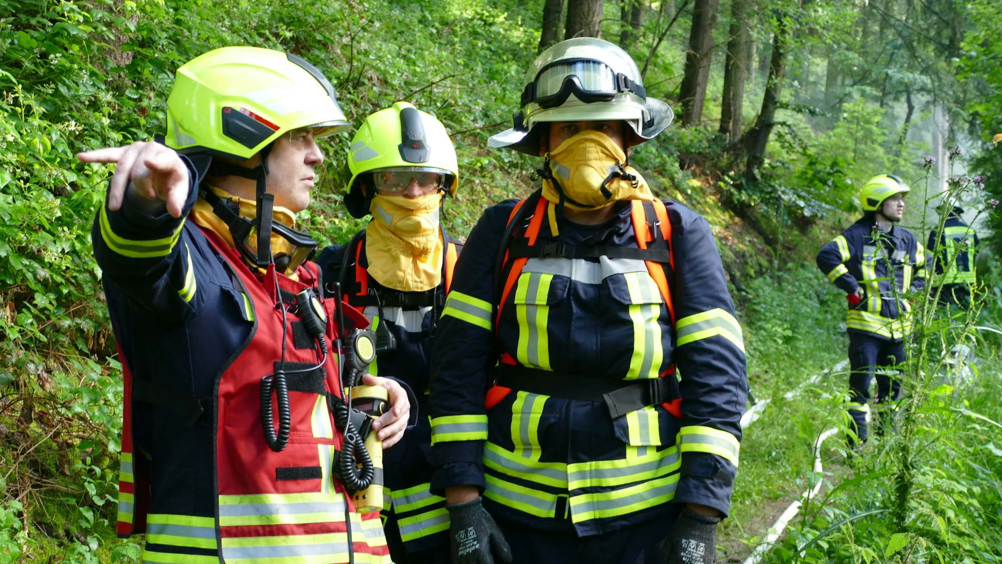 Mit Löschrucksäcken und Schutzmasken vor dem Qualm sind diese beiden Feuerwehrleute ausgestattet.