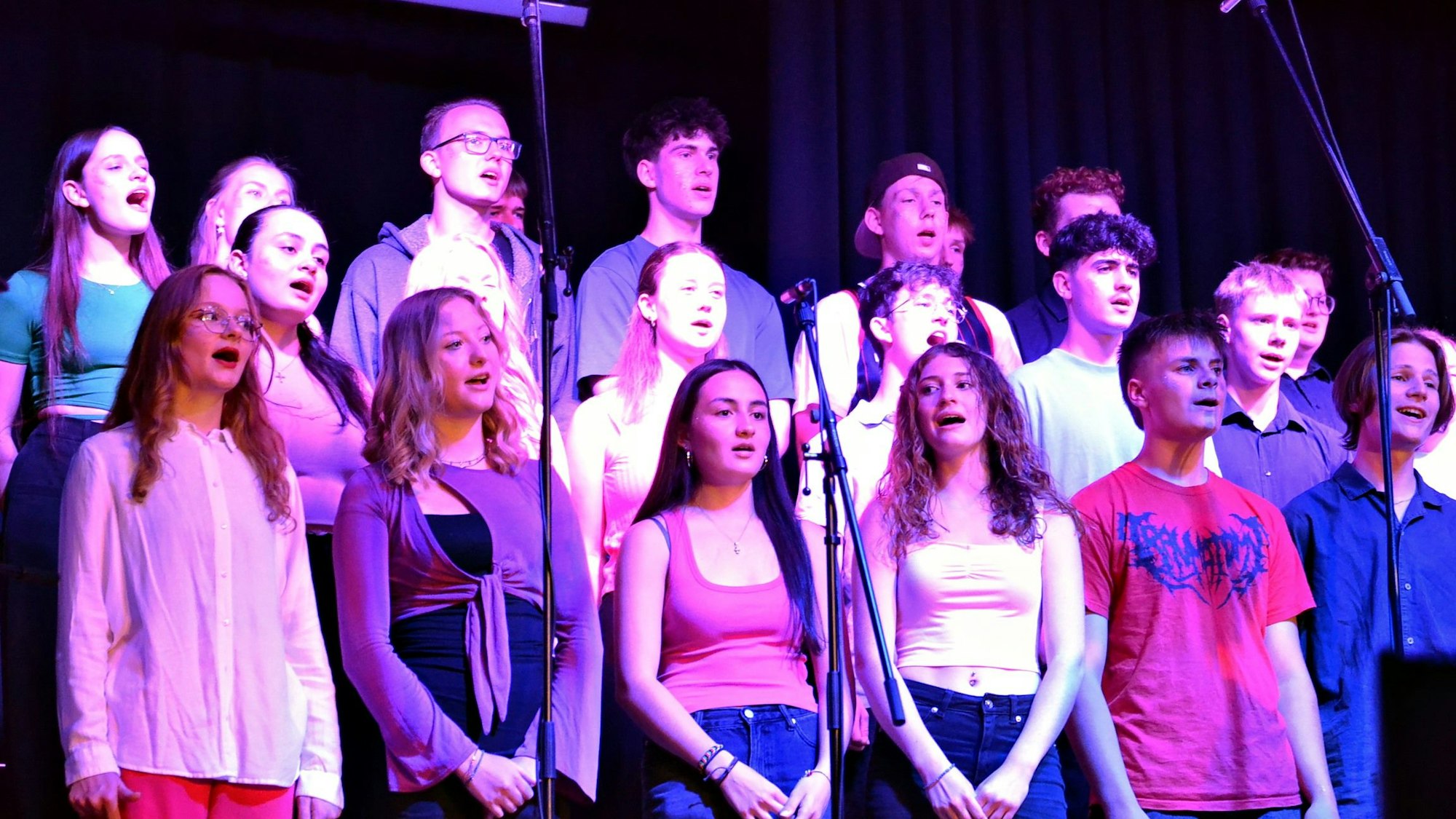Eine Gruppe Jugendlicher steht auf der Bühne und singt.