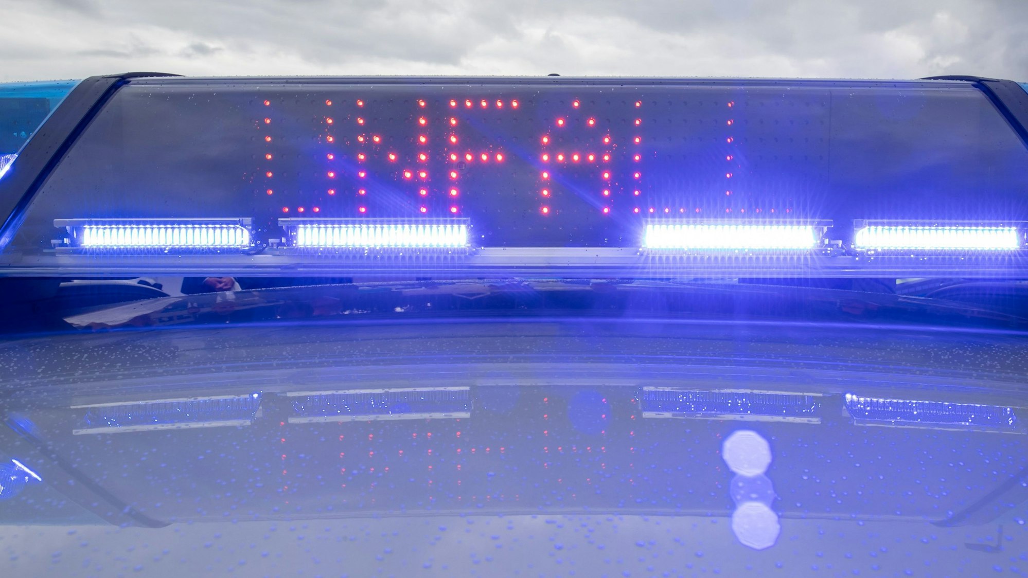 Ein Blaulicht auf dem Dach eines Polizeifahrzeugs mit der LED-Anzeige „Unfall“.