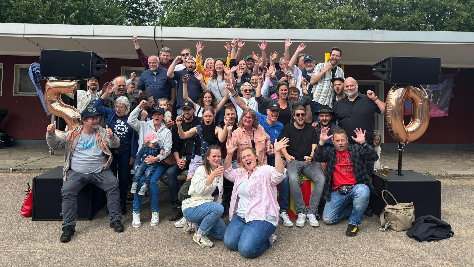 Viele Menschen stehen zusammen und jubeln.