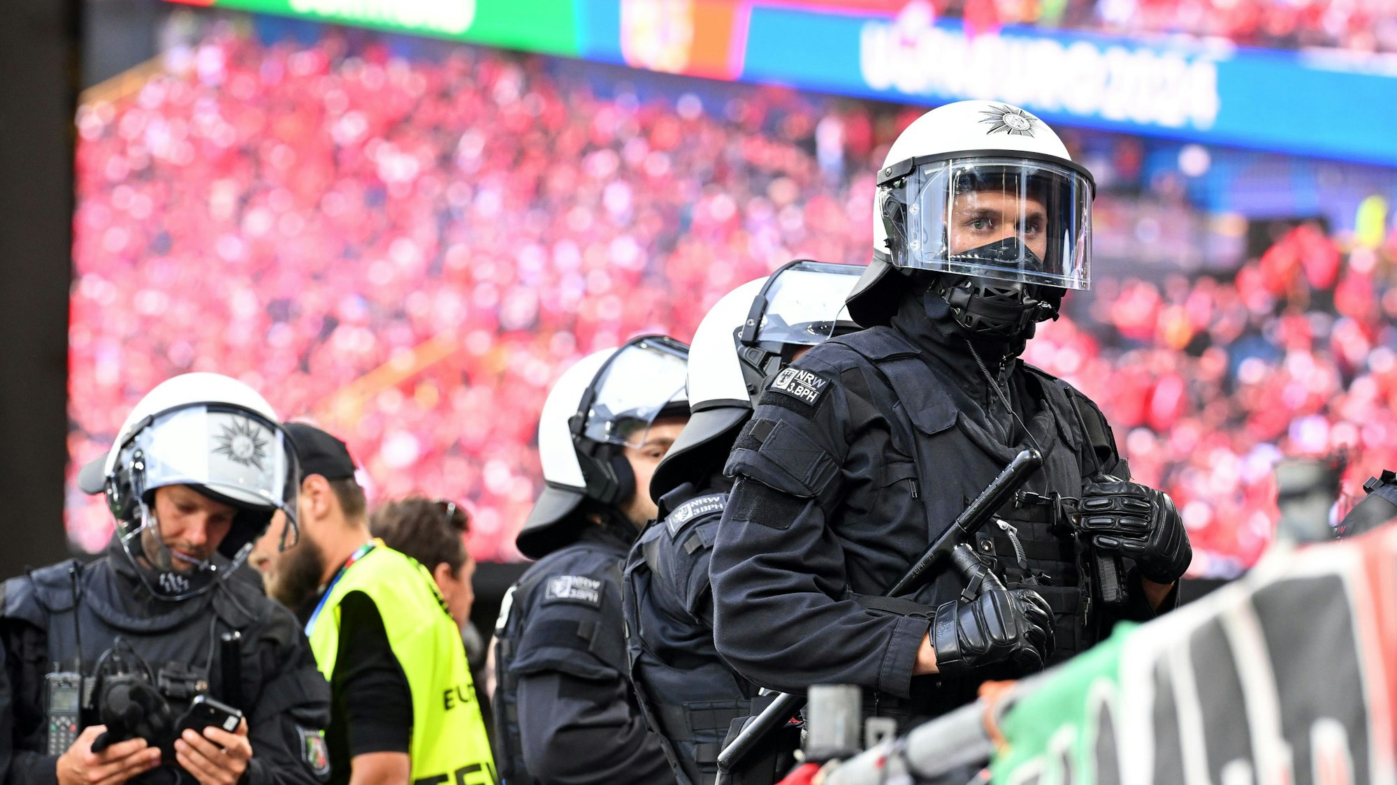 Zu sehen sind Einsatzkräfte der Polizei in einem Fußballstadion.
