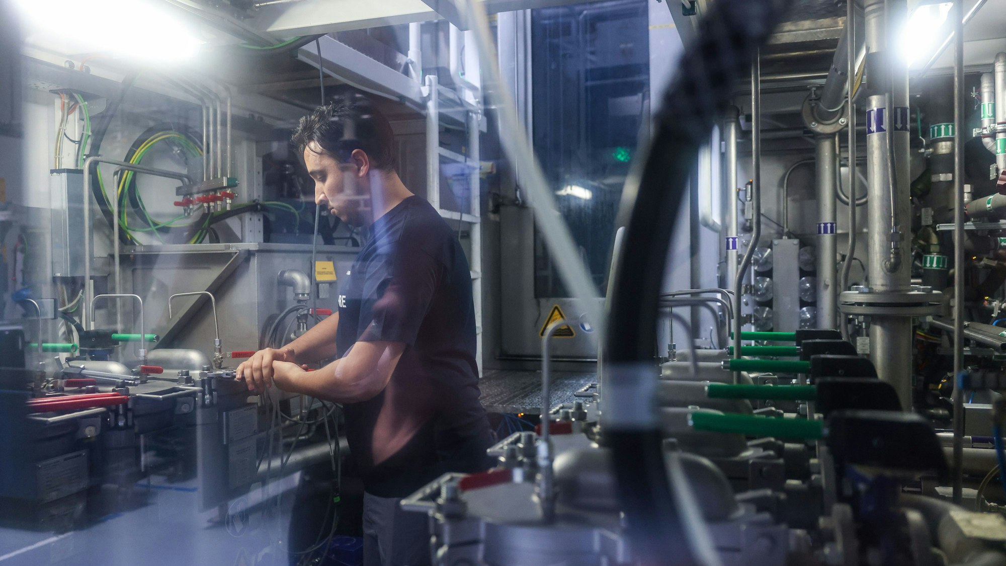 Ein Beschäftigter prüft Verschlüsse einer Filteranlage.