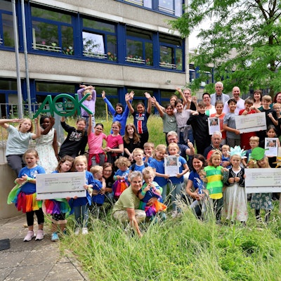 Die Kinder der prämierten Einrichtungen, ihre Begleiter, die Veranstalter und Juroren sowie die Festgäste haben sich zum Gruppenfoto am Gebäude der GGS Nordstadt in Euskirchener zusammengestellt.