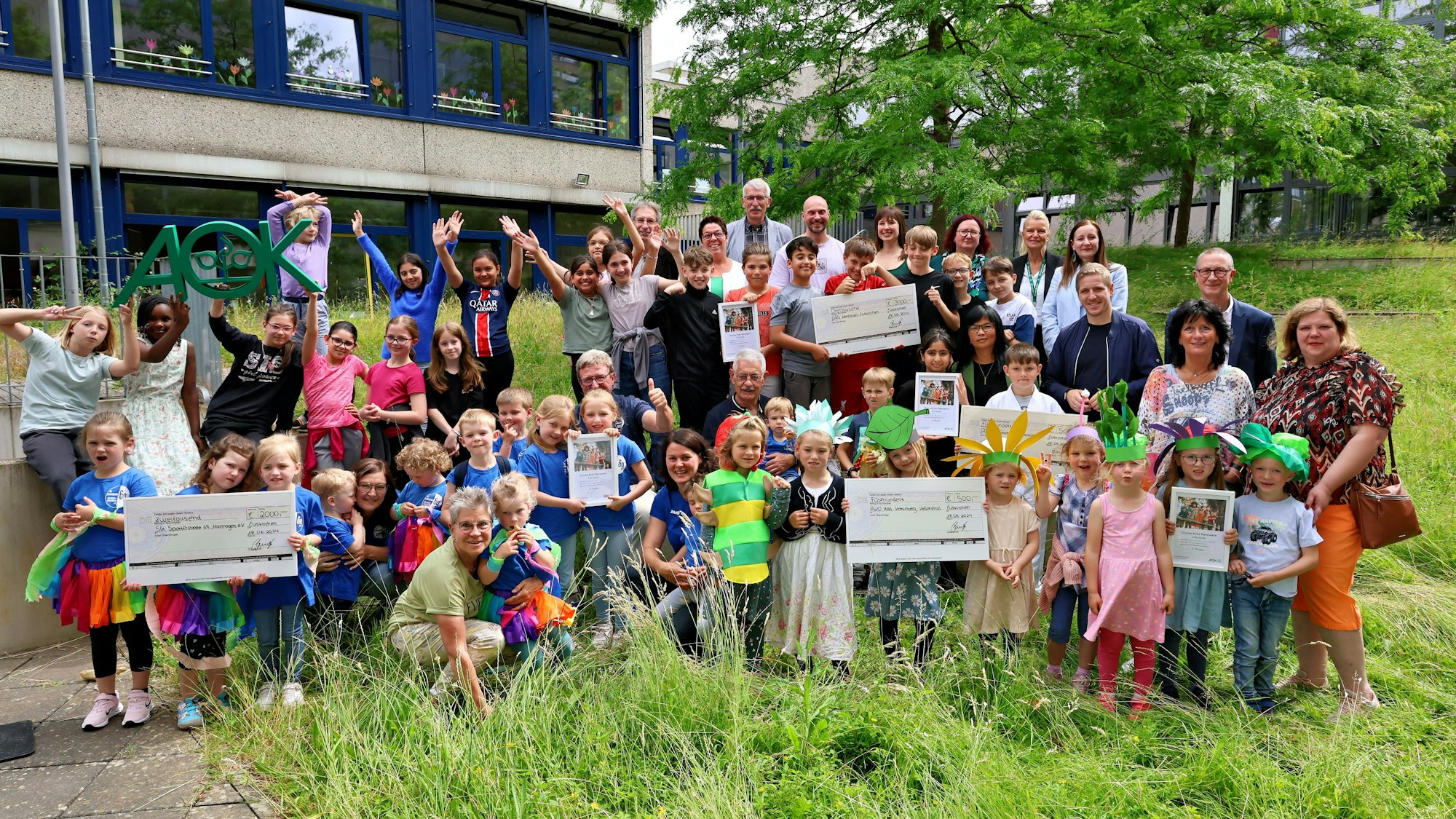 Die Kinder der prämierten Einrichtungen, ihre Begleiter, die Veranstalter und Juroren sowie die Festgäste haben sich zum Gruppenfoto am Gebäude der GGS Nordstadt in Euskirchener zusammengestellt.