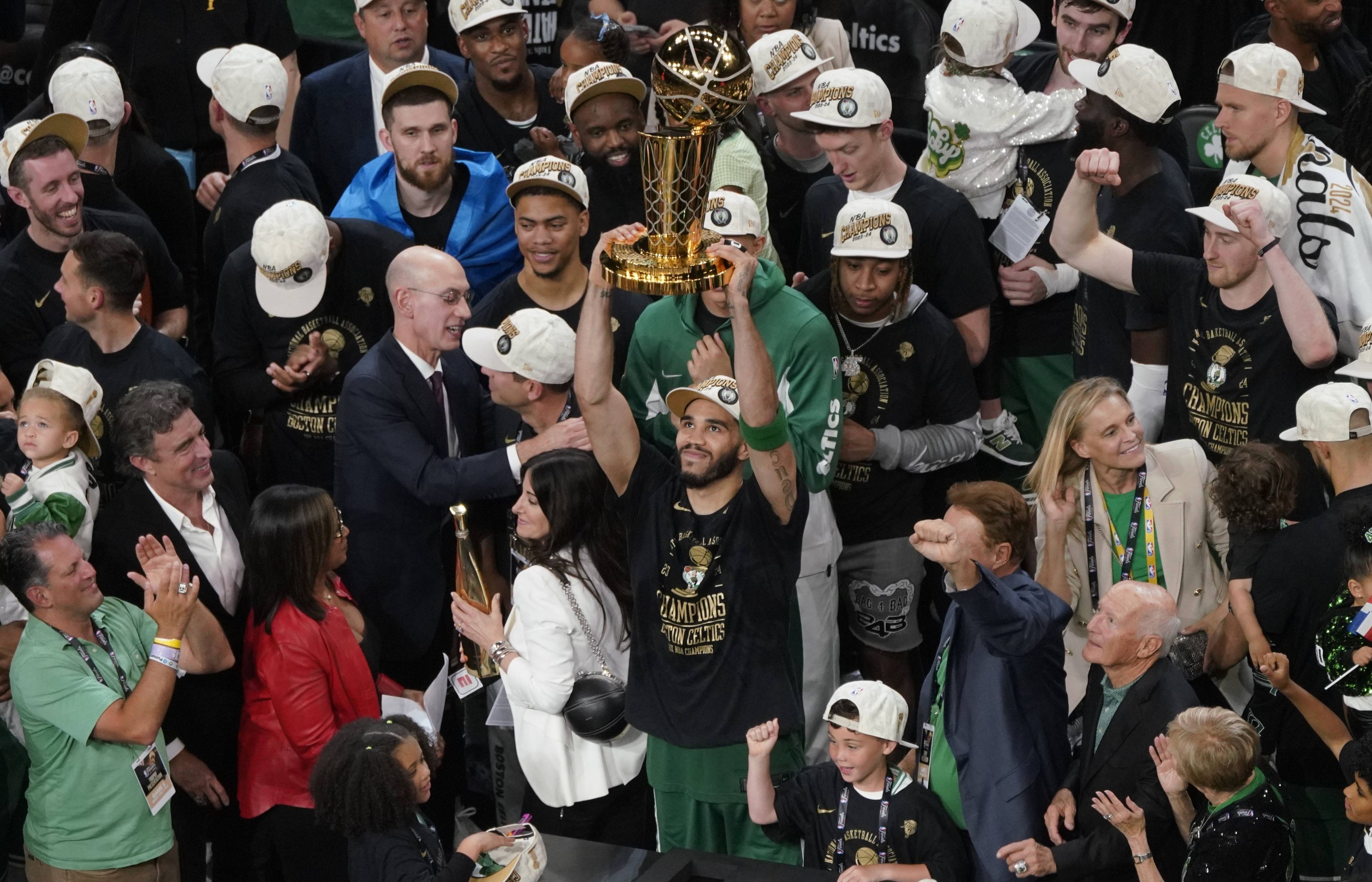 Celtics-Spieler Jayson Tatum hält die Trophäe für den Meistertitel in der NBA hoch.