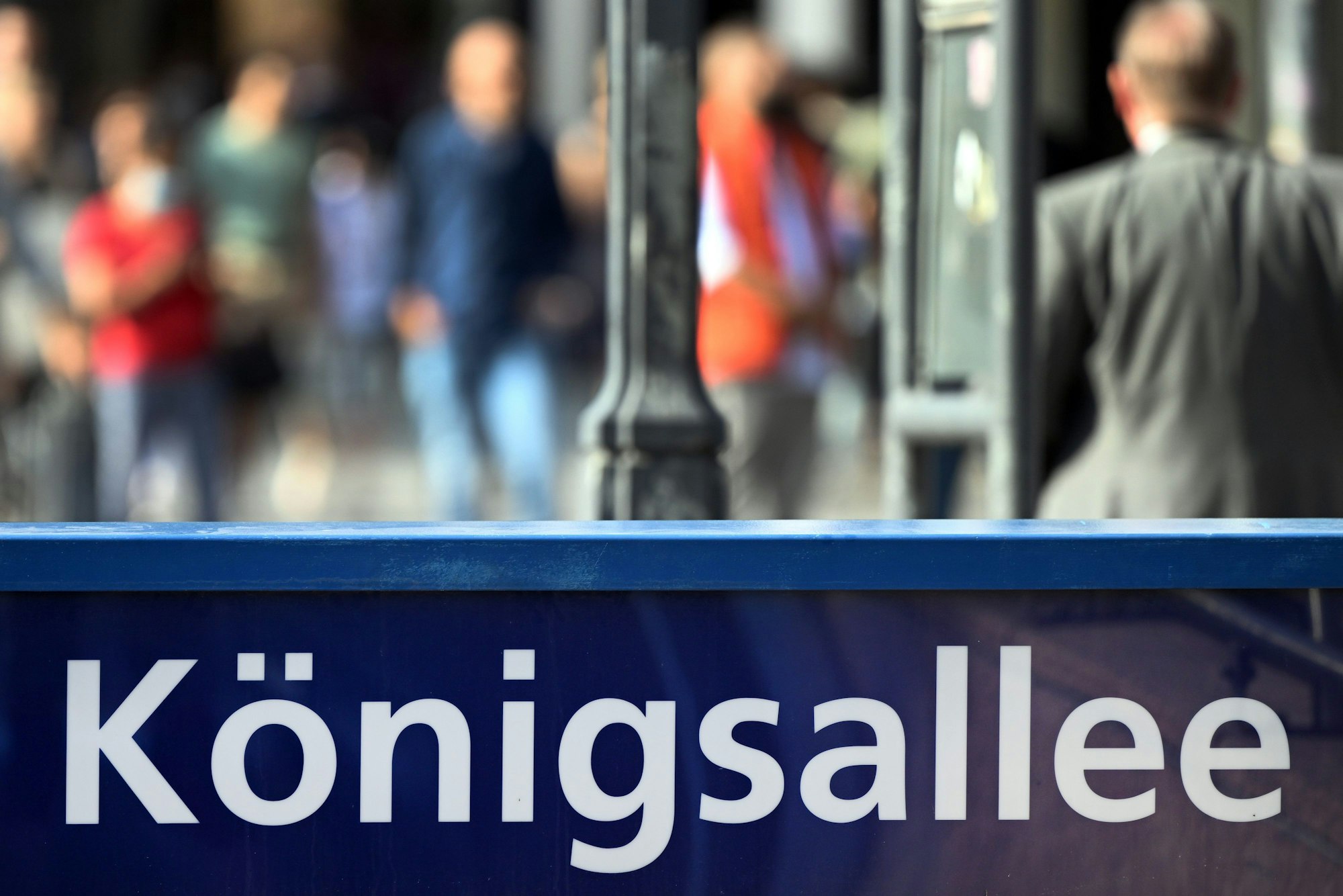 Menschen flanieren auf der Düsseldorfer Prachtstraße Königsallee.