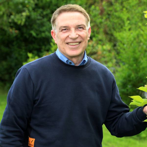 Der langjährige Kreisdirektor des Rheinisch-Bergischen Kreises, Dr. Erik Werdel, steht an einem Baum im Garten seines Hauses in Overath-Heiligenhaus.