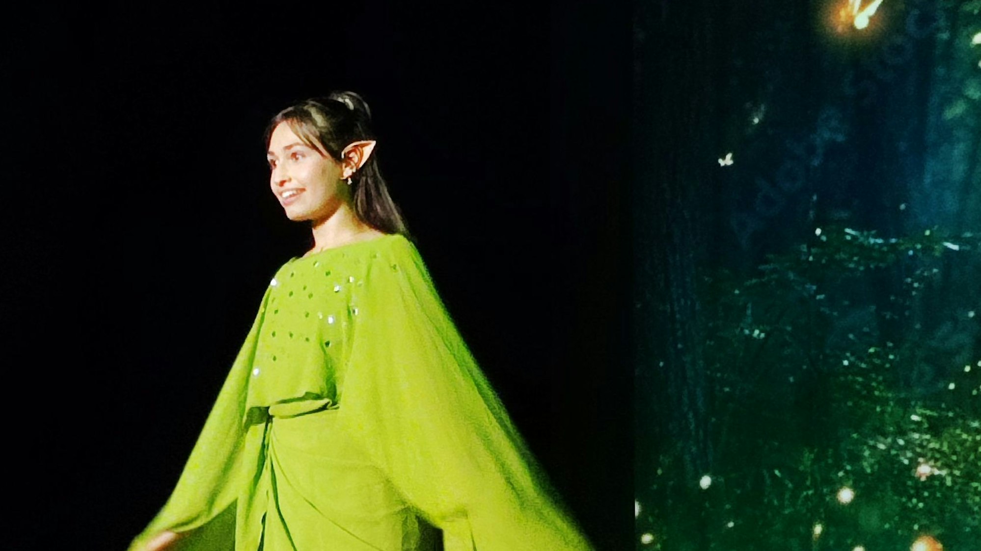 Eine Schülerin, verkleidet als Elfe, mit grünem Gewand und spitzen Ohren.