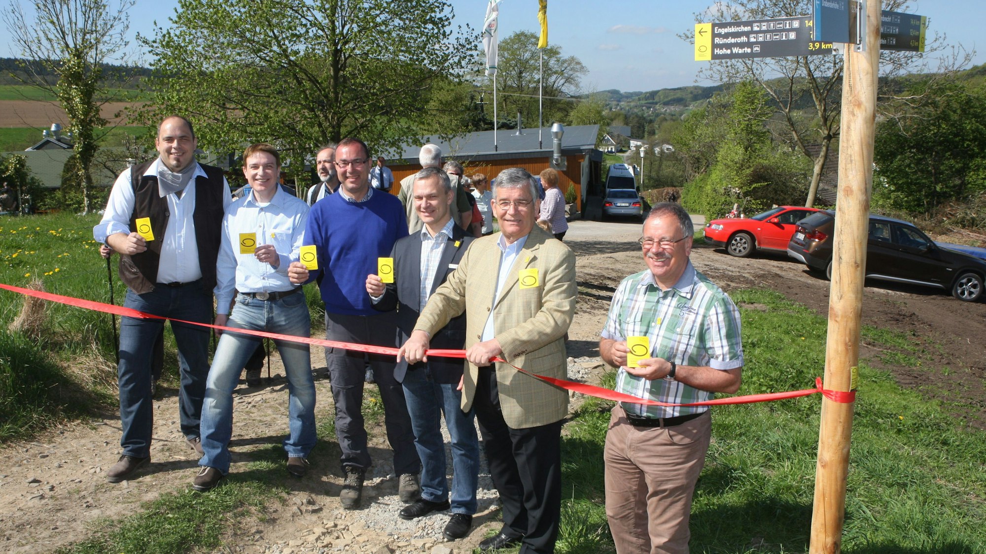 Menschen schneiden ein Band zur Eröffnung des Bergischen Panoramasteigs durch.