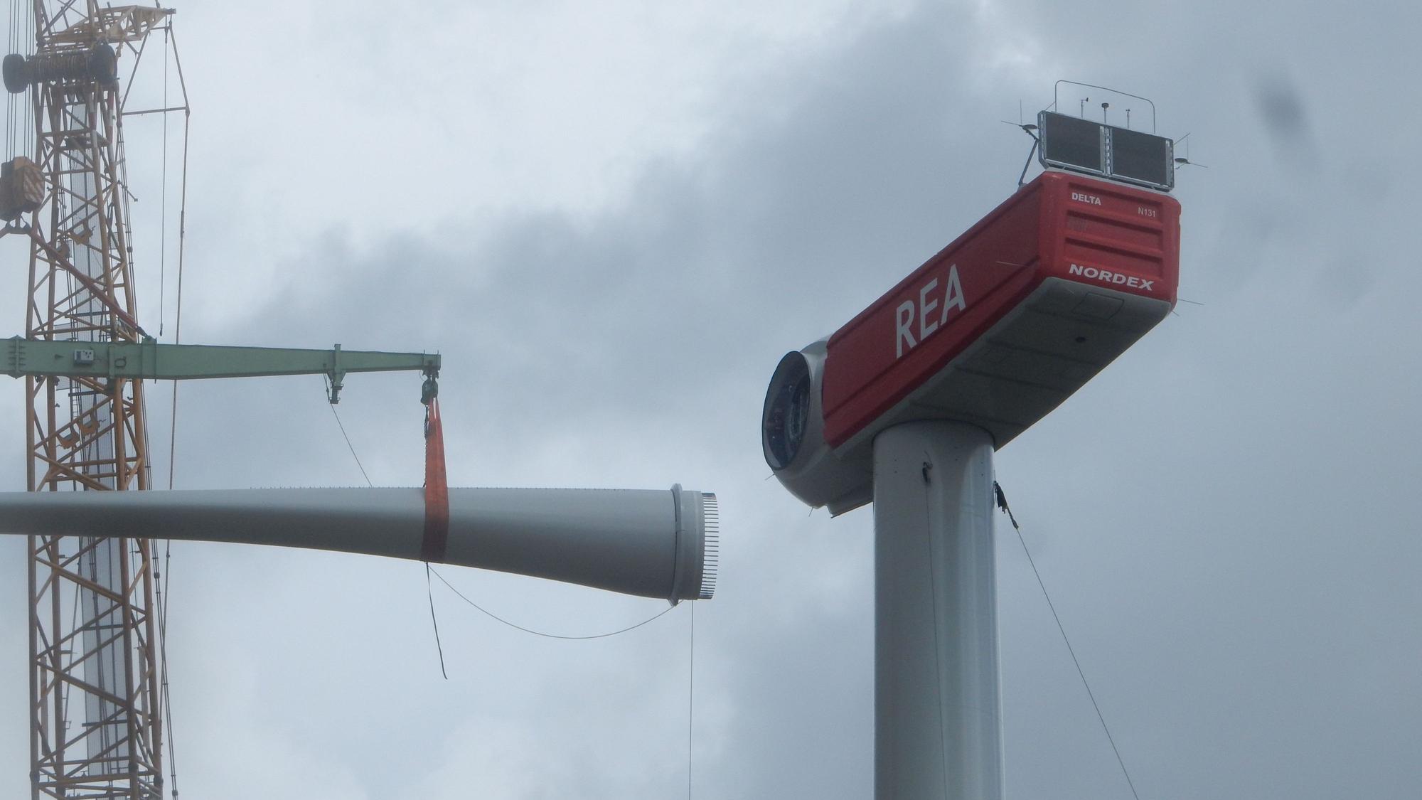 Ein Rotorblatt wird an der Windkraftanlage eingesetzt.