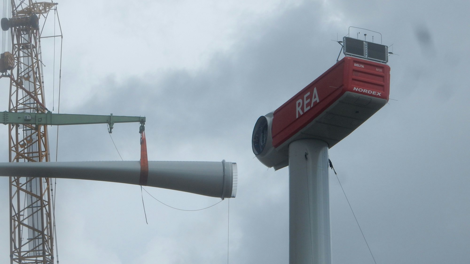 Ein Rotorblatt wird an der Windkraftanlage eingesetzt.