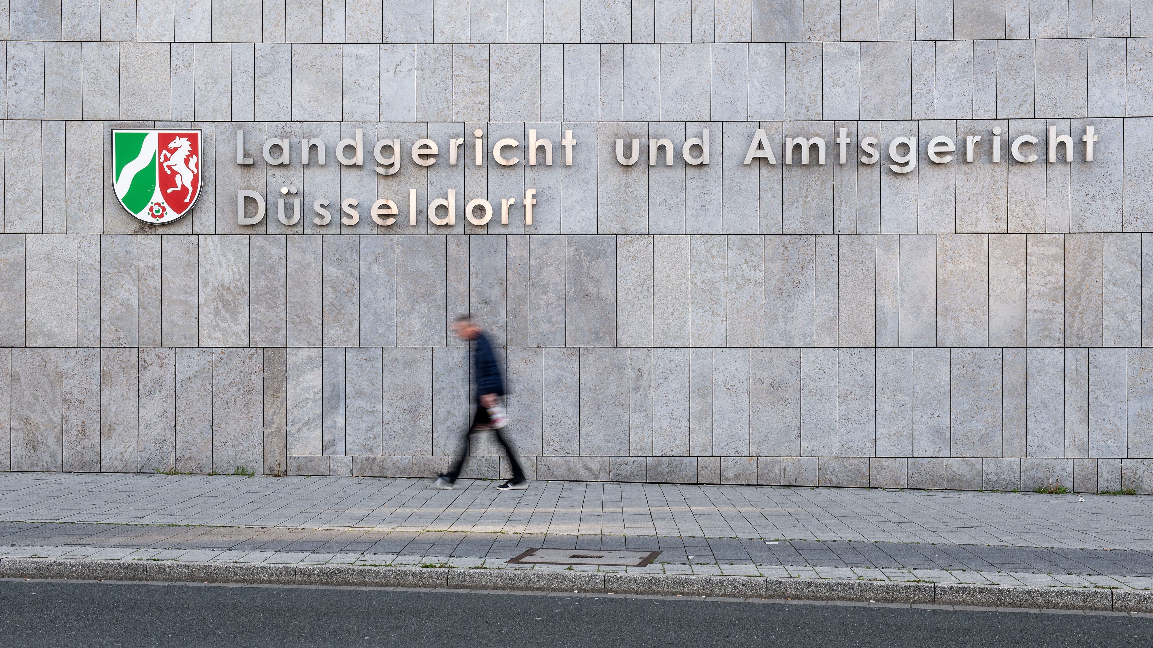 ARCHIV - 29.04.2019, Nordrhein-Westfalen, Düsseldorf: Ein Fußgänger geht am Amtsgericht Düsseldorf vorbei. (zu dpa: «Prozess um Tod einer Katze - vom Balkon gestoßen») Foto: Marius Becker/dpa +++ dpa-Bildfunk +++