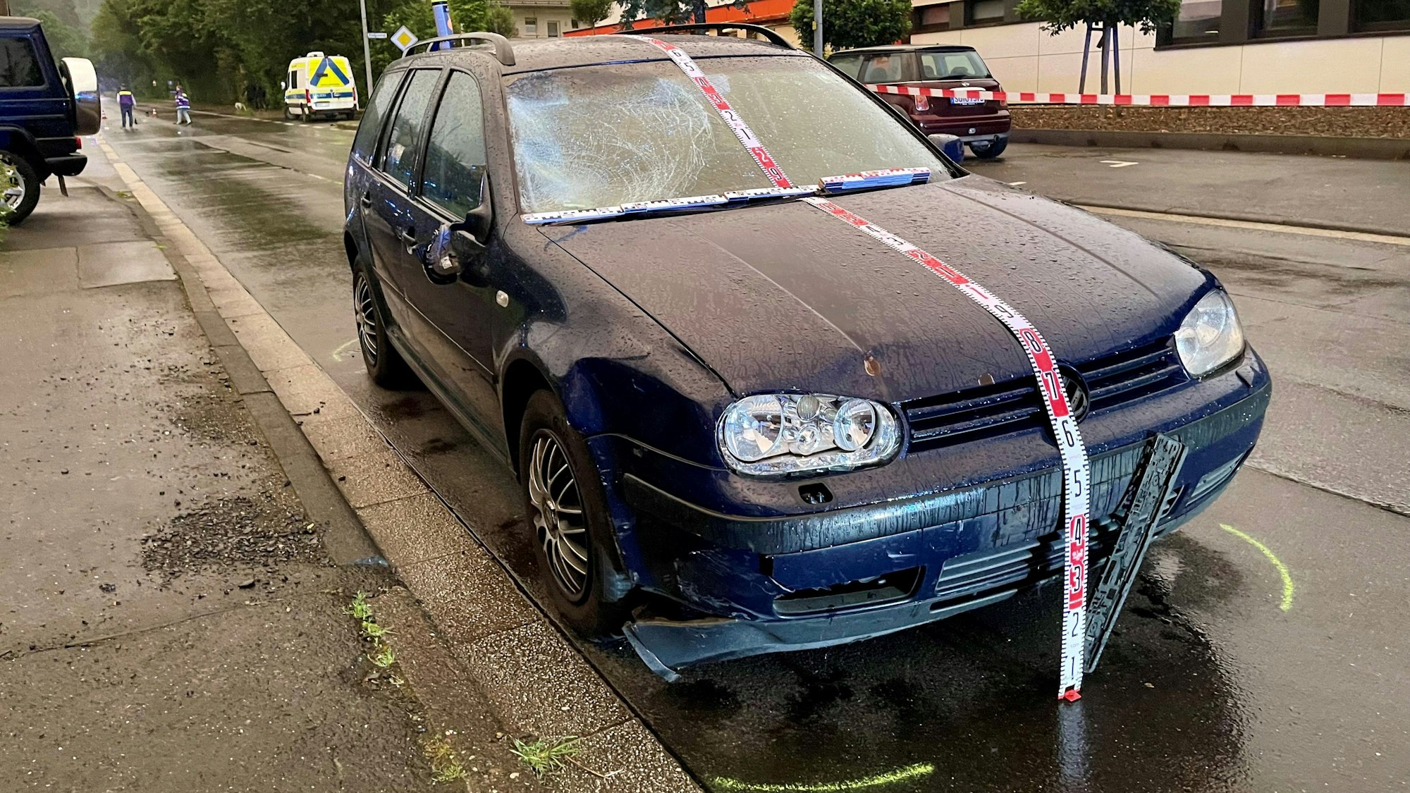 Ein dunkles Fahrzeug mit zersplitterter Frontscheibe.