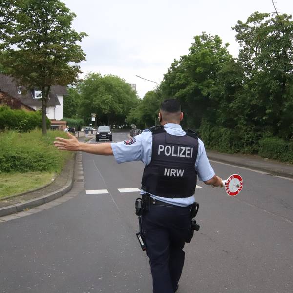 Ein Polizist winkt einen Autofahrer zu einer Kontrolle heraus.