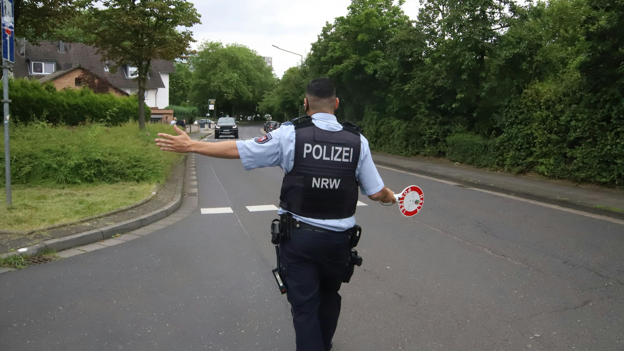 Ein Polizist winkt einen Autofahrer zu einer Kontrolle heraus.