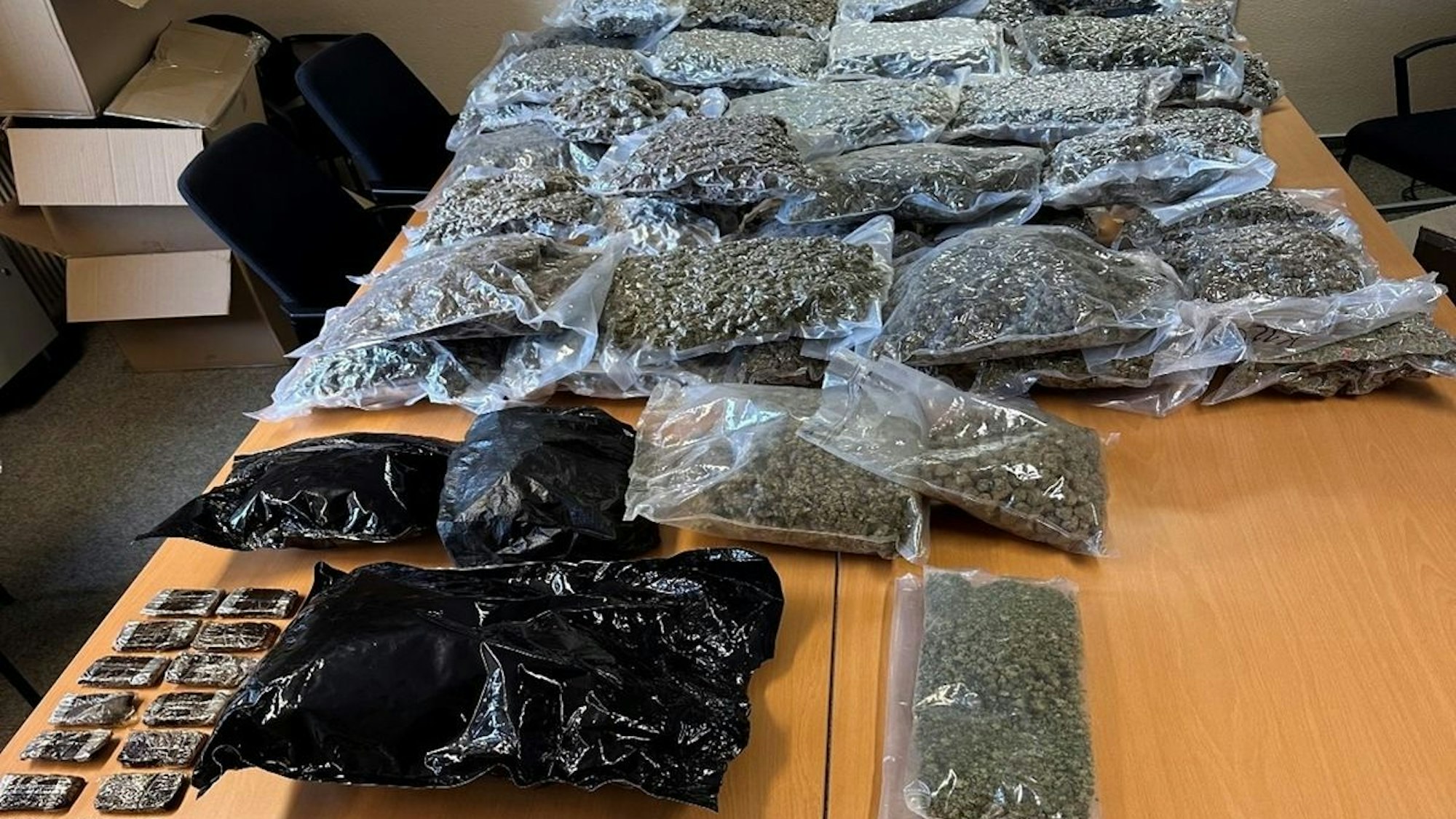 Auf einem Tisch liegen zahlreiche Plastiktüten, gefüllt mit Betäubungsmitteln.