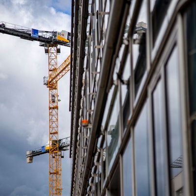 Zwei Baukräne schweben über einem Bauprojekt.