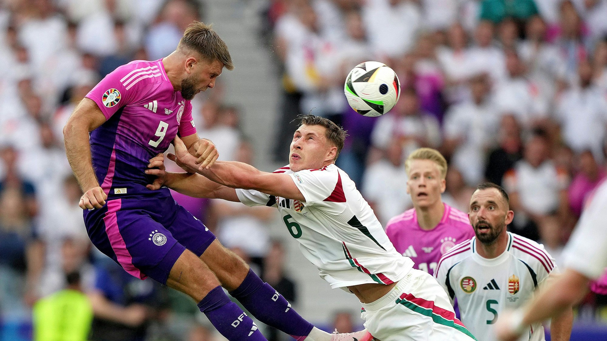 Germany's Niclas Fuellkrug, left, heads the ball as Hungary's Willi Orban defends during a Group A match between Germany and Hungary at the Euro 2024 soccer tournament in Stuttgart, Germany, Wednesday, June 19, 2024. (Spada/LaPresse via AP)