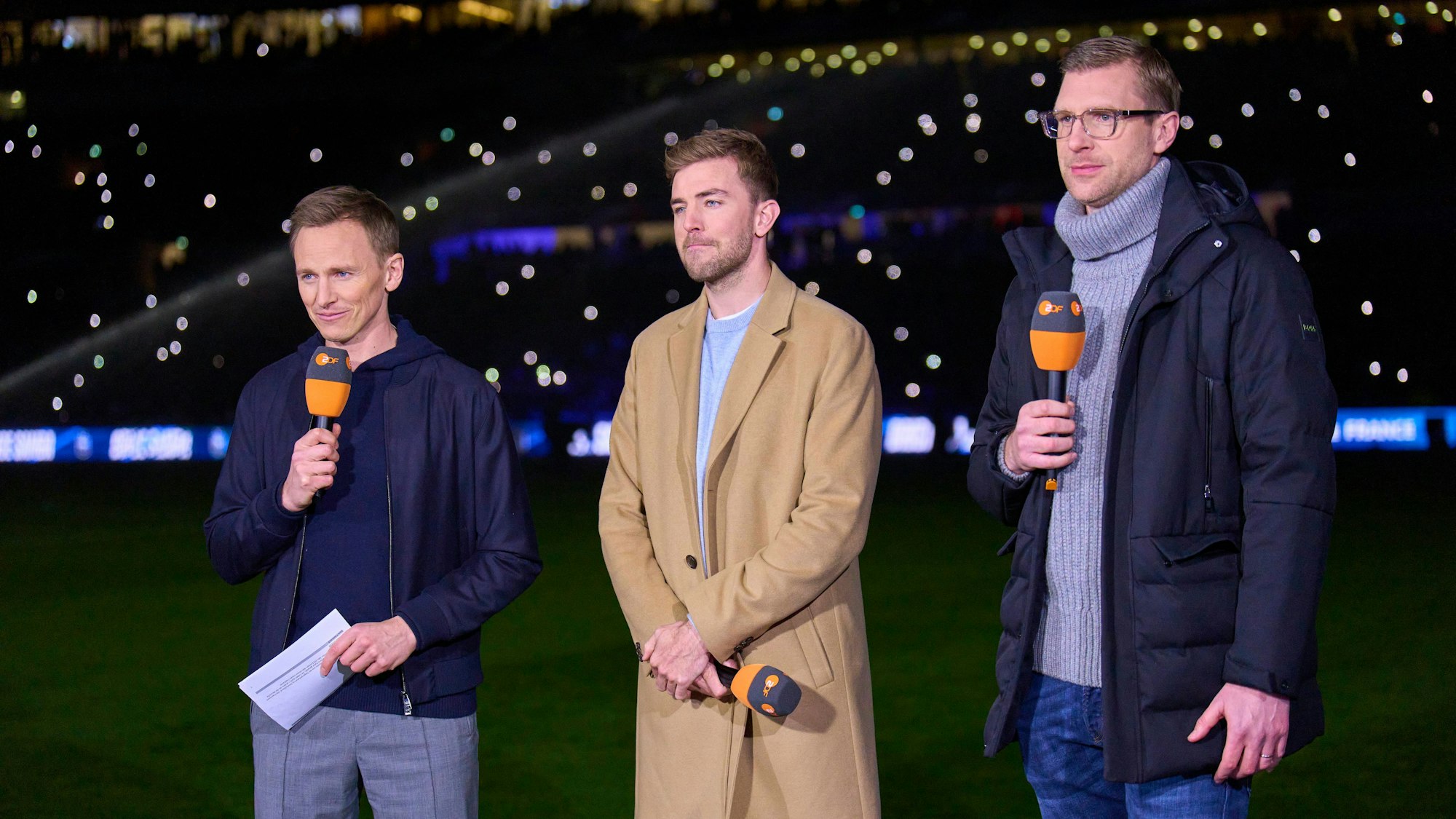 Jochen Breyer, Christoph Kramer und Per Mertesacker stehen gemeinsam am Spielfeldrand (Archivbild).