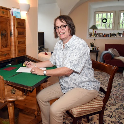 Lioba von Detten sitzt in in ihrer Wohnung in Schloss Ehreshoven bei Engelskirchen an einem Sekretär aus dem 19. Jahrhundert.