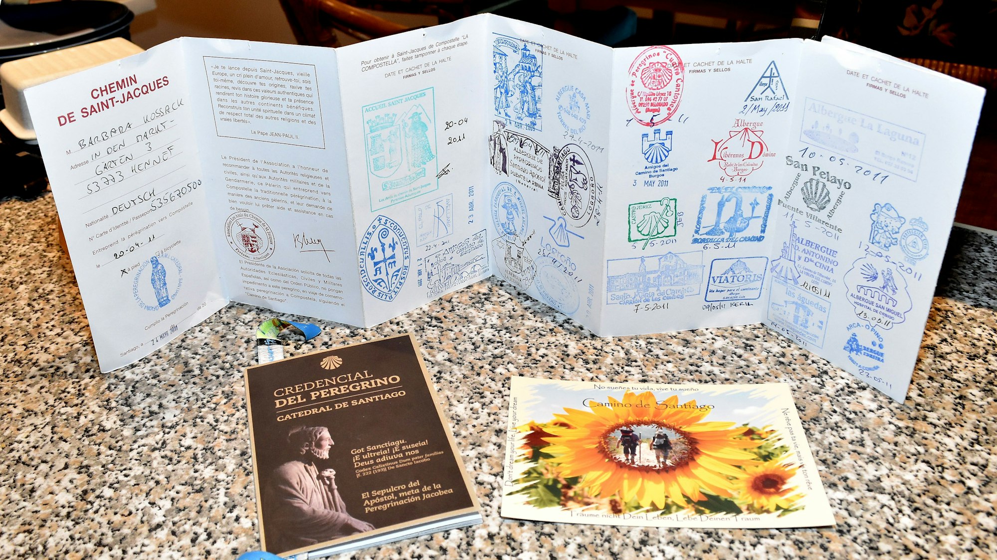 Ein aufgefalteter Pilgerpass mit zahlreichen Stationsstempeln.