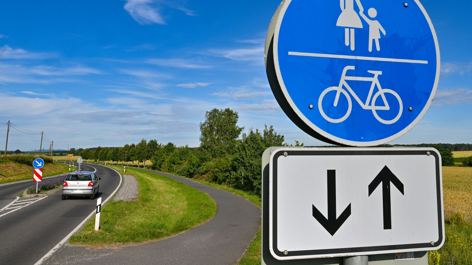 Das Bild zeigt einen Weg mit einem Verkehrsschild «Gemeinsamer Geh- und Radweg».